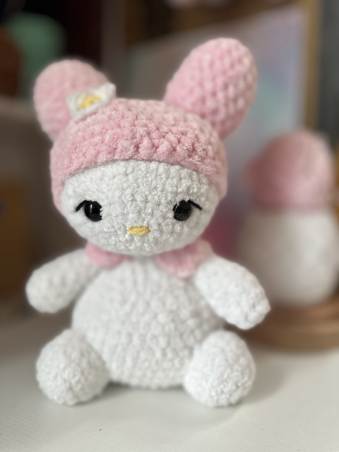 Handmade white crochet bunny wearing a pink hood