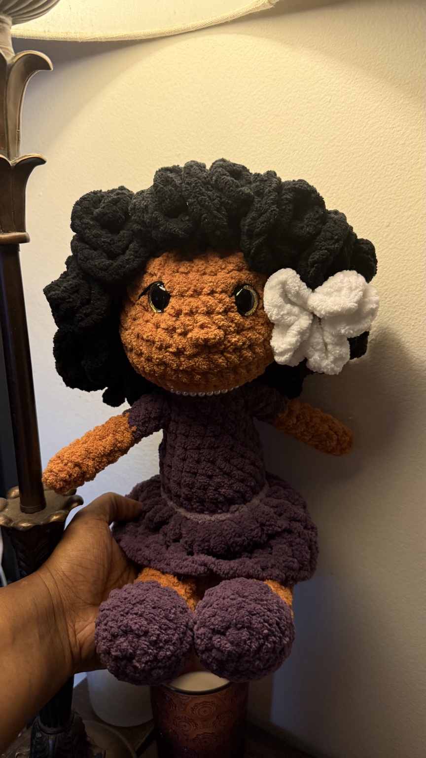Handmade crochet doll with black curls, purple dress and white flower
